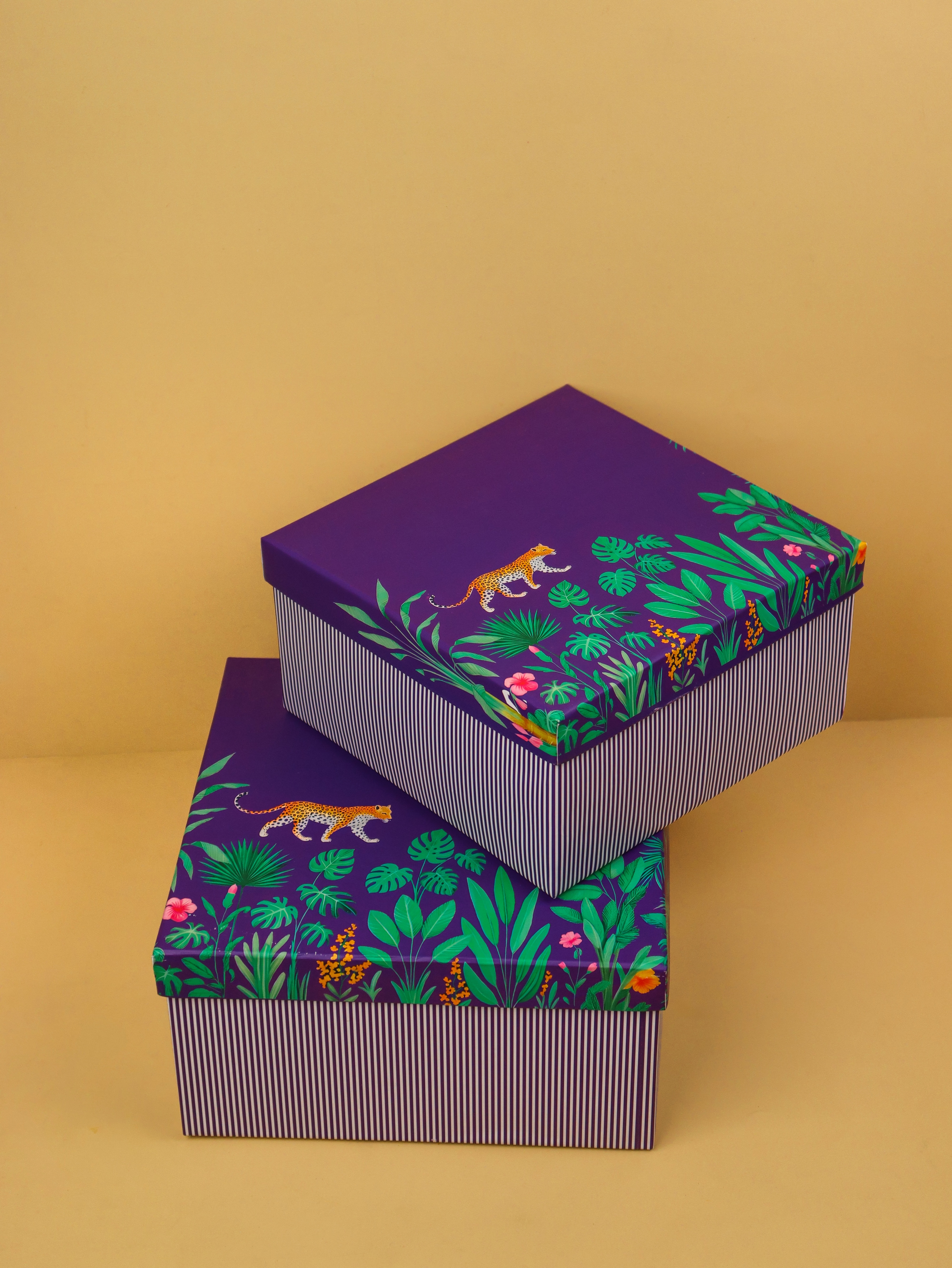 The signature Wrapscene aubergine gift box with a satin ribbon, lit by soft window light.